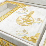 Détails calligraphie arabe dorée en relief sur coffret Coran artisanal