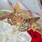 Détail papillon doré sur composition florale artisanale