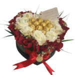 Composition symétrique de roses et chocolats dans une boîte cœur noire.