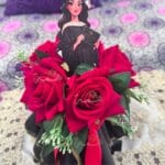 Gros plan sur un bouquet de graduation personnalisé, roses rouges et figurine de fin d'études fait main par Hemma o Chan au Maroc.